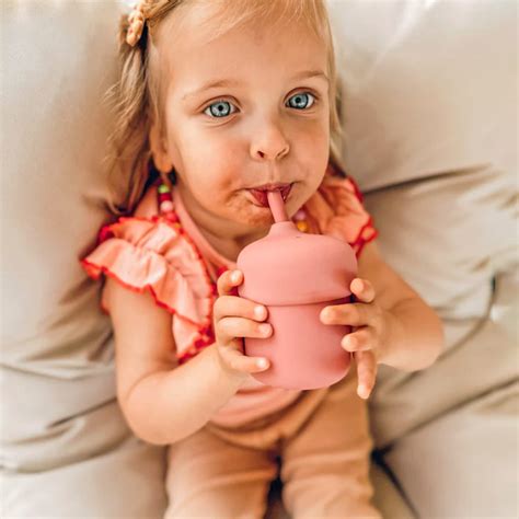 Ilustrácia dieťaťa pijúceho z farebného pohárika so slamkou